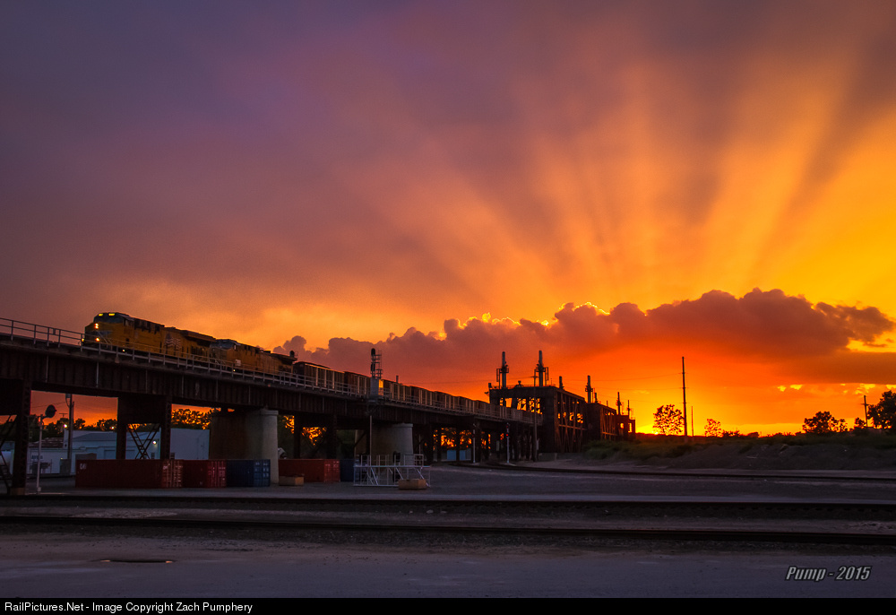 A spectacular sunset explodes in the western sky behind UP Train 2CNRFG